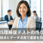 明るいオフィスで笑顔を見せる管理部門の日本人女性。手元のノートパソコンには「LMS理解度テスト」の作成画面が表示され、画像下部には「LMS理解度テストの作り方：自動採点とデータ活用で運営を効率化」というタイトルが重なっています。背景には仕事に取り組む同僚の姿が見えます。